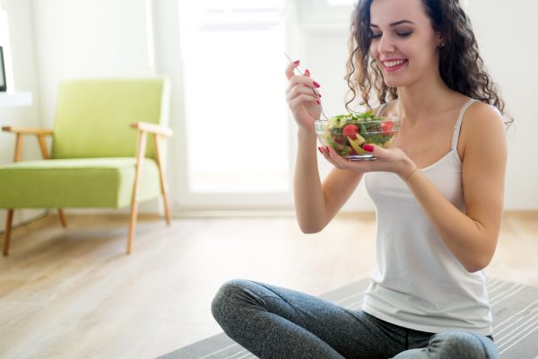 Fitness young woman eating healthy food after workout